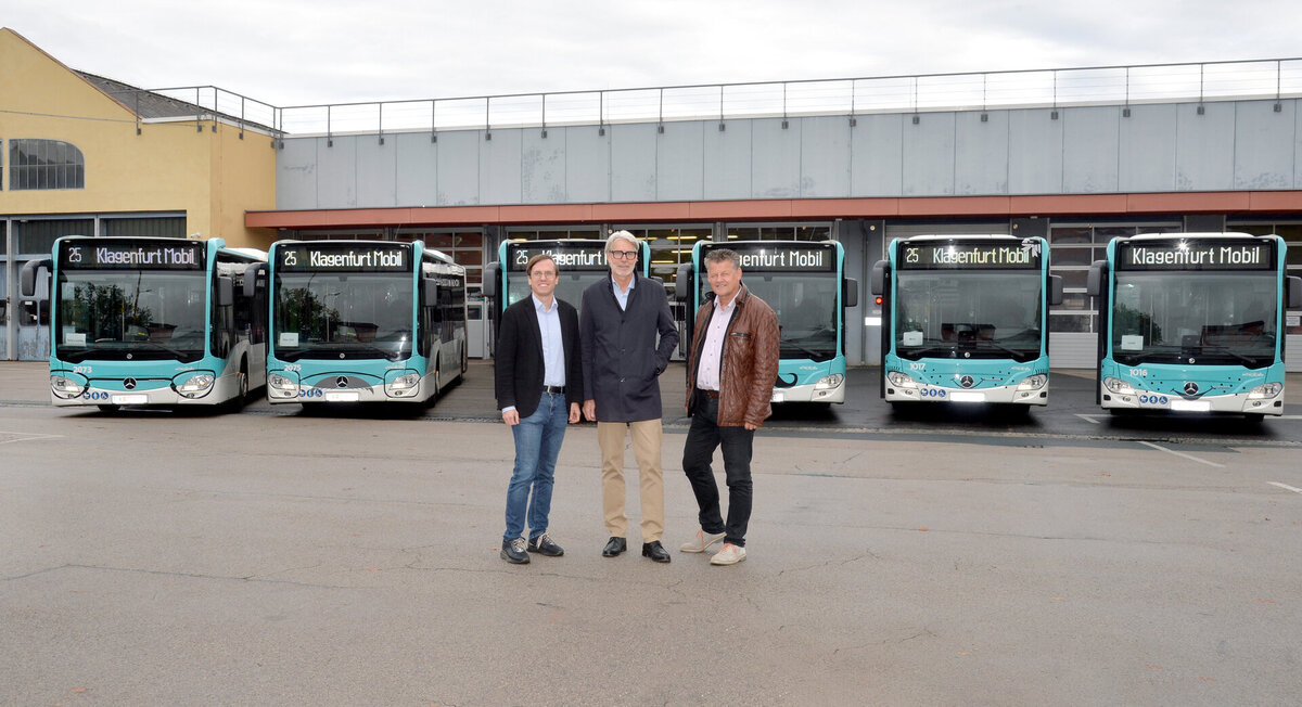 Klagenfurt Mobil Busse mit drei Männern vor einem Gebäude in Klagenfurt
