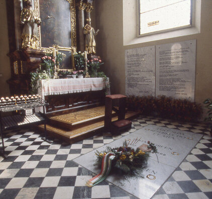 Grabplatte von Julien Green mit Steintafeln an der Kirchenmauer, seitlich ein Altar©StadtPresse/Eggenberger