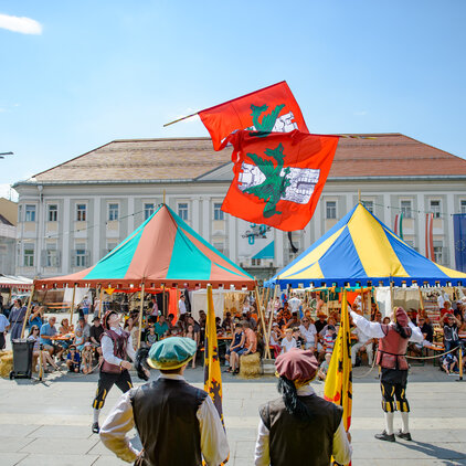 Stadtfahnen und buntes Treiben beim Mittelalterfest auf dem Neuen Platz©StadtPresse/Hude