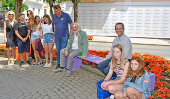 Die Schüler und Lehrer der NMS Hasnerschule mit den Stadträten Frank Frey und Mag. Franz Petritz auf einer der bunten Sitzbänke in der Bahnhofstraße.  Foto: StadtPresse/Glinik