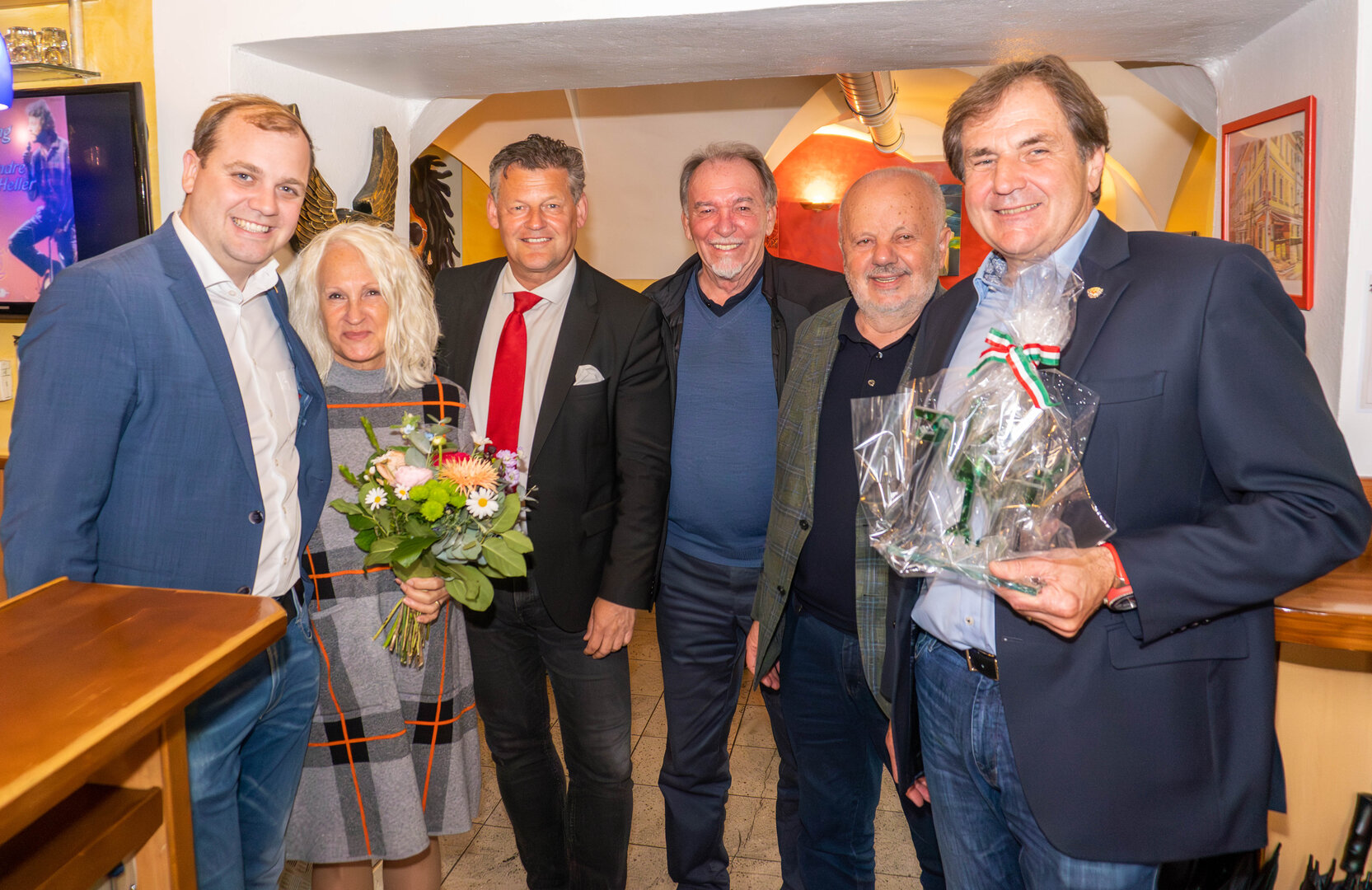 Bürgermeister Christian Scheider und Gemeinderat Patrick Jonke  gratulierten Markus Hudelist (ganz rechts) zum Geburtstag und überreichten  ihm den Gläsernen Lindwurm der Landeshauptstadt. Viele Stammgäste waren  anwesend. Foto: StadtKommunikation/Wiedergut
