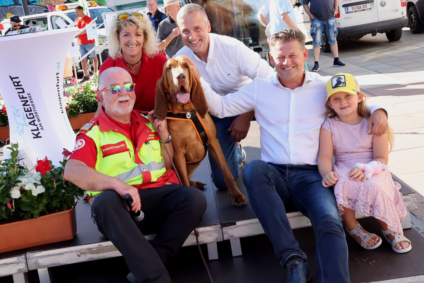 Suchhund „Willi“ konnte Bürgermeister Christian Scheider wieder erfolgreich aufspüren. Franz Blatnik (Samariterbund), Hundeführerin Alexandra Grunow, GR Michael Gussnig sowie Bürgermeister Christian Scheider mit Tochter Mia beim Klagenfurter Tierschutztag auf dem Neuen Platz. Foto: Wajand