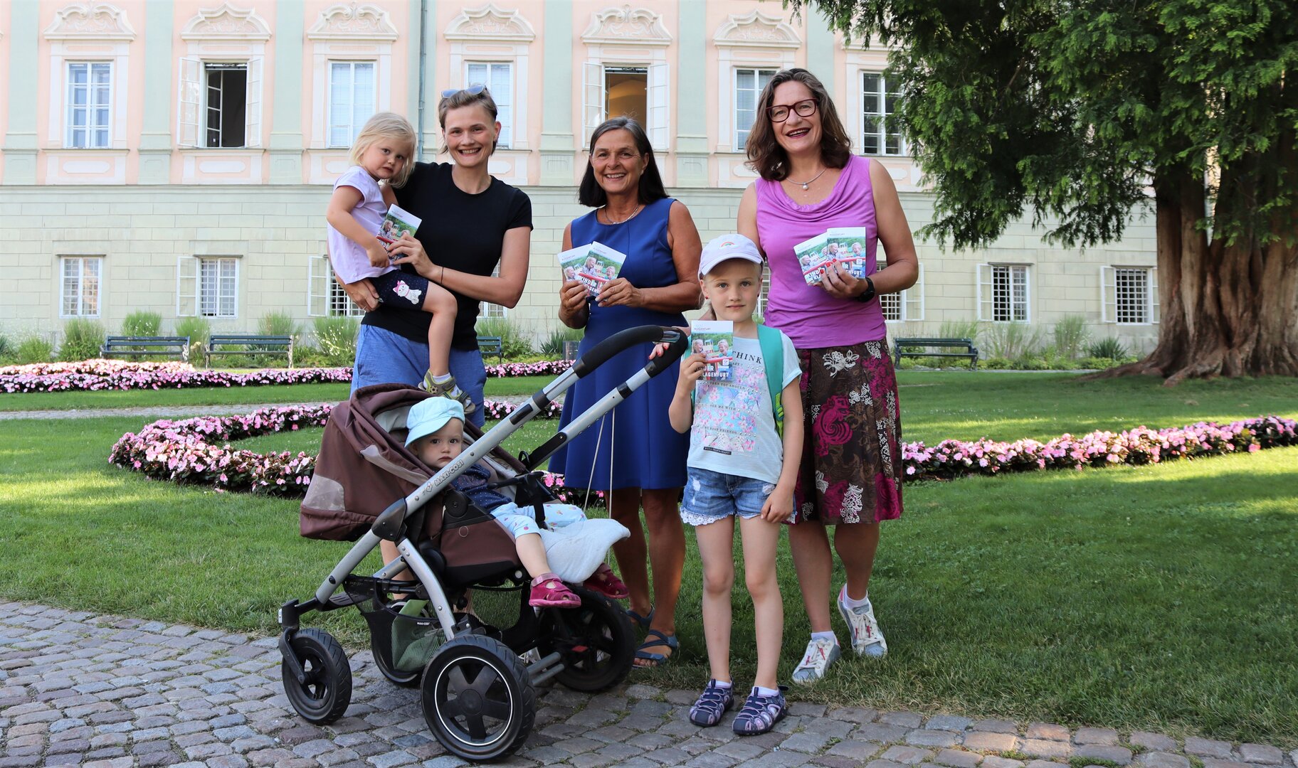 Die Kinder freuen sich gemeinsam mit Mag.a Astrid Malle und Stadträtin DI Constance Mochar über die neuen Broschüren „Kinder in Klagenfurt“. Foto: StadtKommunikation/Zechner