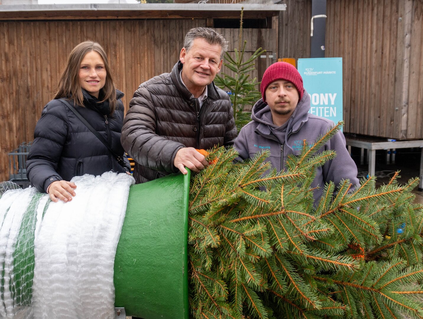 Sozial- und Marktreferent Bürgermeister Christian Scheider gemeinsam mit Marktkoordinatorin Martina Derhaschnig und einem ihrer Mitarbeiter bei der Christbaum-Verteilaktion am Neuen Platz. Foto: StadtKommunikation/Zechner
