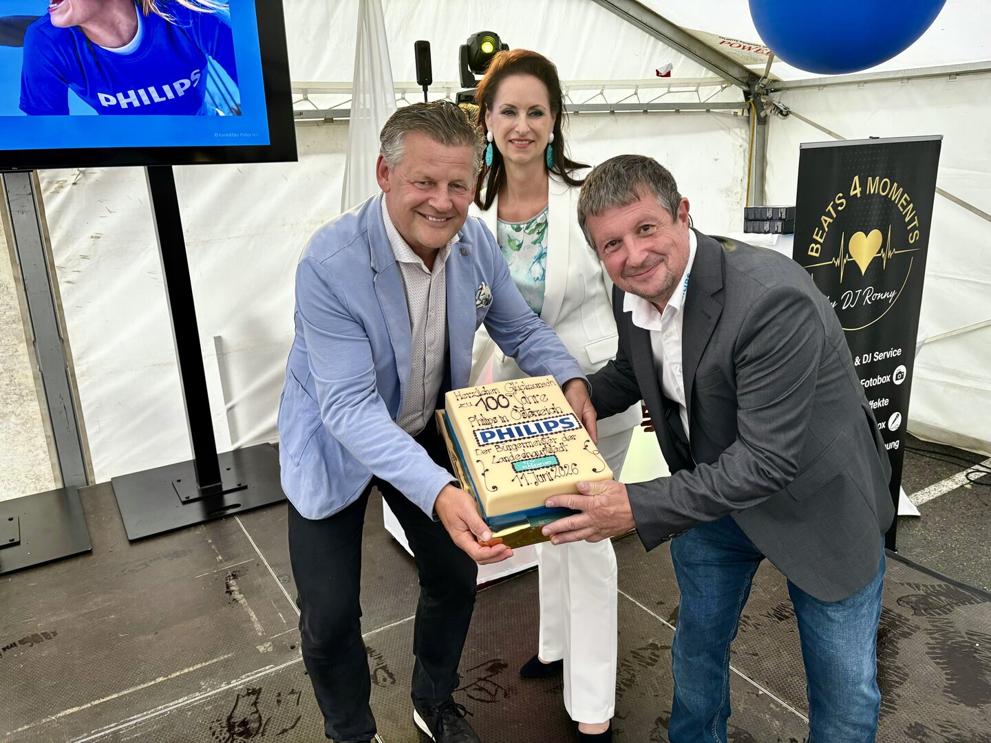 Bürgermeister Christian Scheider gratulierte Hans-Peter Rammel (Standortleiter von Philips Klagenfurt) und Ilse Rapatz (Leiterin der Personalabteilung) zum 100-Jahr-Jubiläum. Foto: Büro Bürgermeister