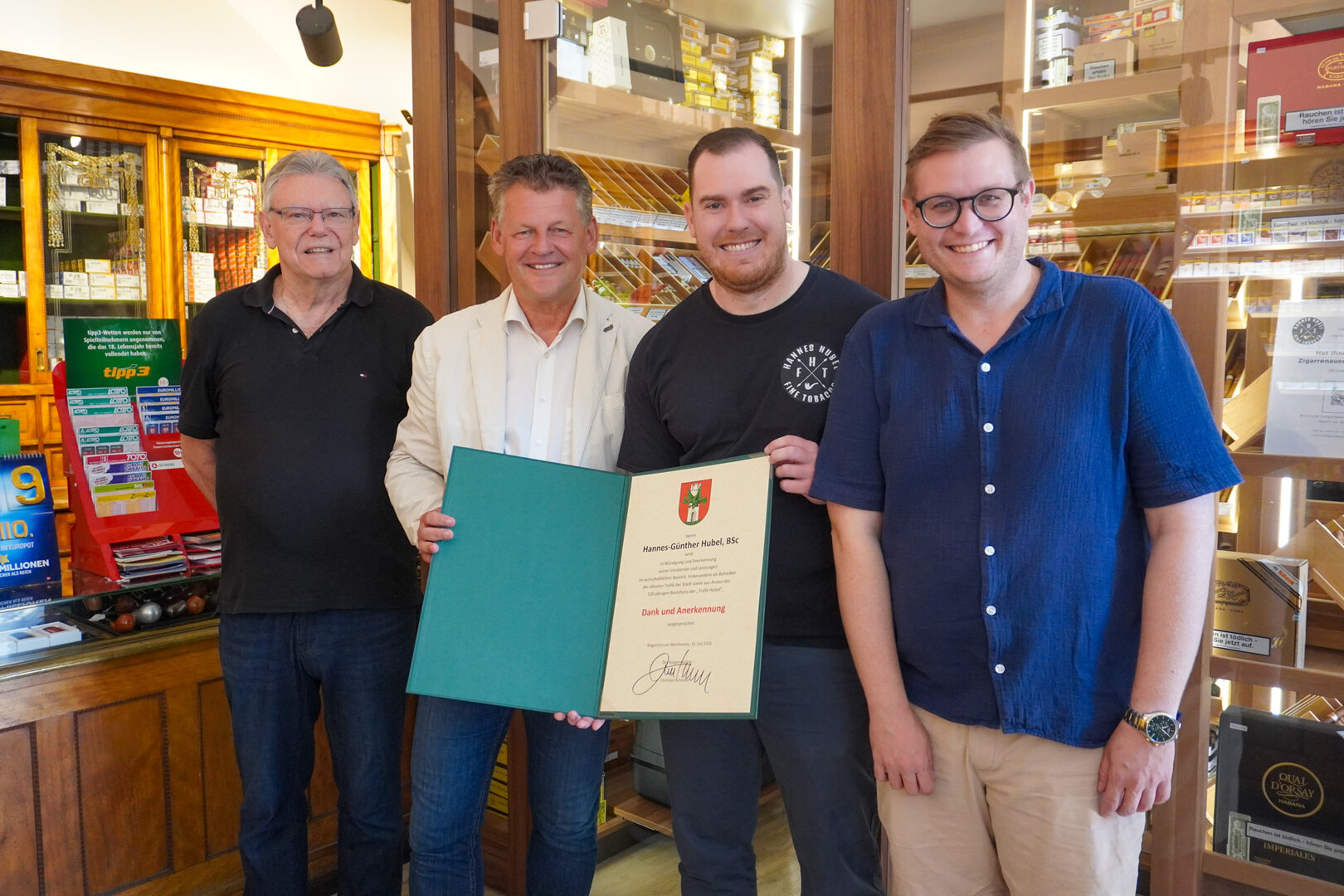 Bürgermeister Christian Scheider überreichte gemeinsam mit Wirtschaftsstadtrat Julian Geier die Dank- und Anerkennungsurkunde der Landeshauptstadt an Hannes-Günther Hubel, BSc und Vater Günther Hubel. Foto: StadtKommunikation/Zechner