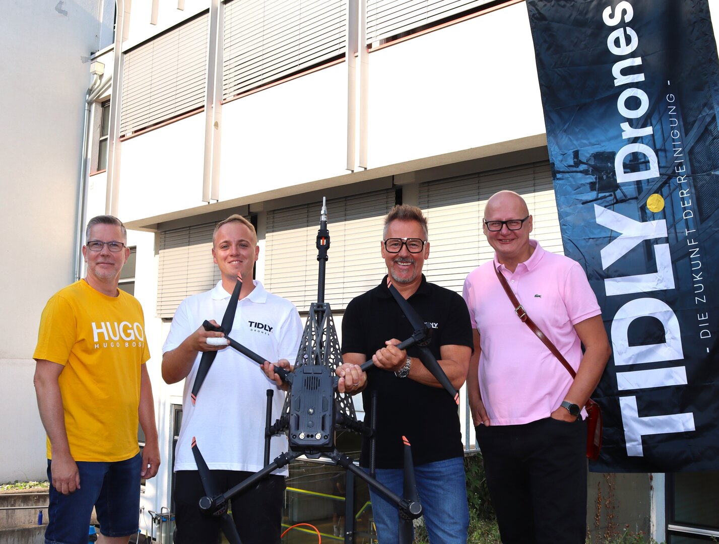 V.l.n.r. Hermann Paier (Abteilung Facility Management), Valentin Baur (Einsatzleiter), Thomas Schneeberger (Geschäftsführer von Tidly Drones) und DI Robert Slamanig (Leiter der Abteilung Facility Management) bei der Fensterreinigung mittels Drohne am Schulstandort St. Ruprecht. Foto: StadtKommunikation/Buchner