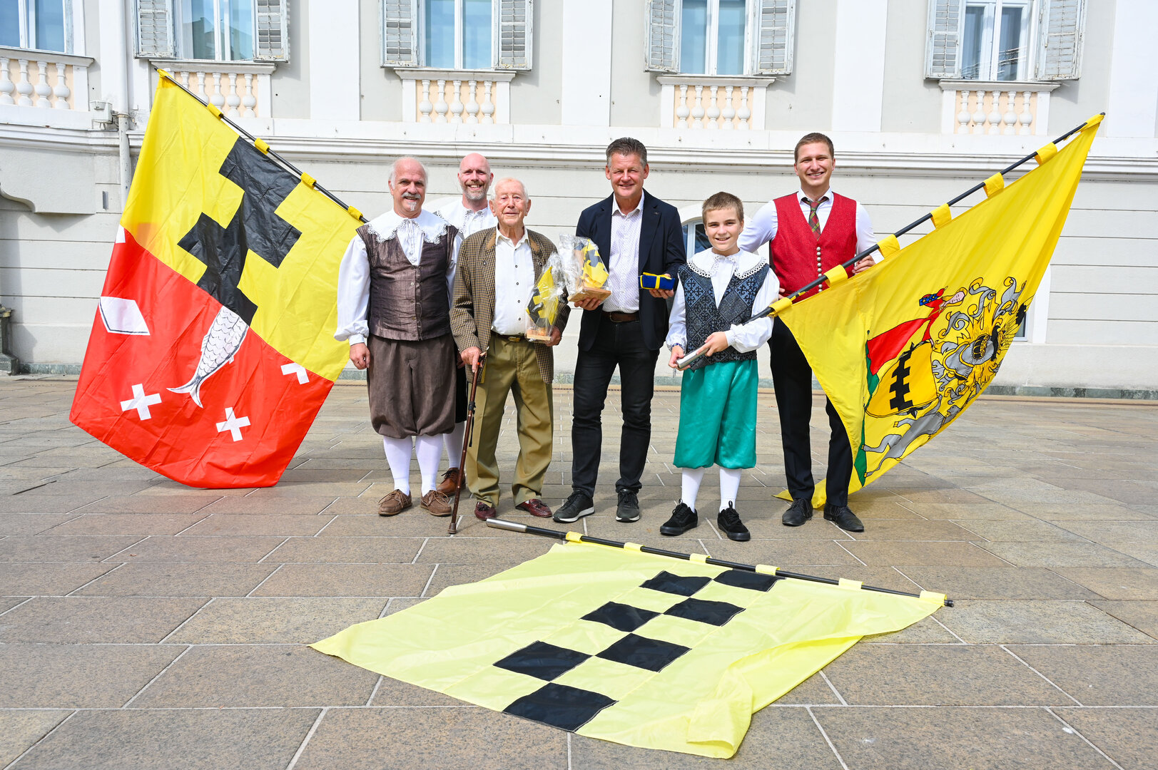 Bürgermeister Christian Scheider mit den Fahnenschwingern aus Brüssel und David Werdinig bei der Vorführung am Neuen Platz. Foto: StadtKommunikation/Hronek