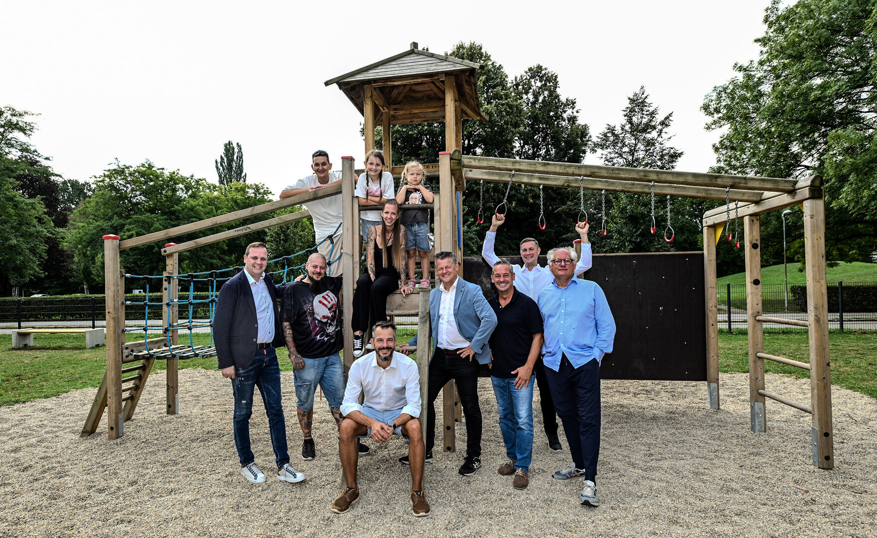 Bürgermeister Christian Scheider, Vizebürgermeister Patrick Jonke, Gemeinderat Dieter Schmied, „Klagenfurt Wohnen“-Geschäftsführer Gerhard Scheucher und Kollege Andreas Binder sowie Quartiersmanager Patrick Slanovc mit den ersten Spielplatznutzern bei der Eröffnung des neu gestalteten Spielplatzes in der Fischlsiedlung.  Foto: StadtKommunikation / Hude