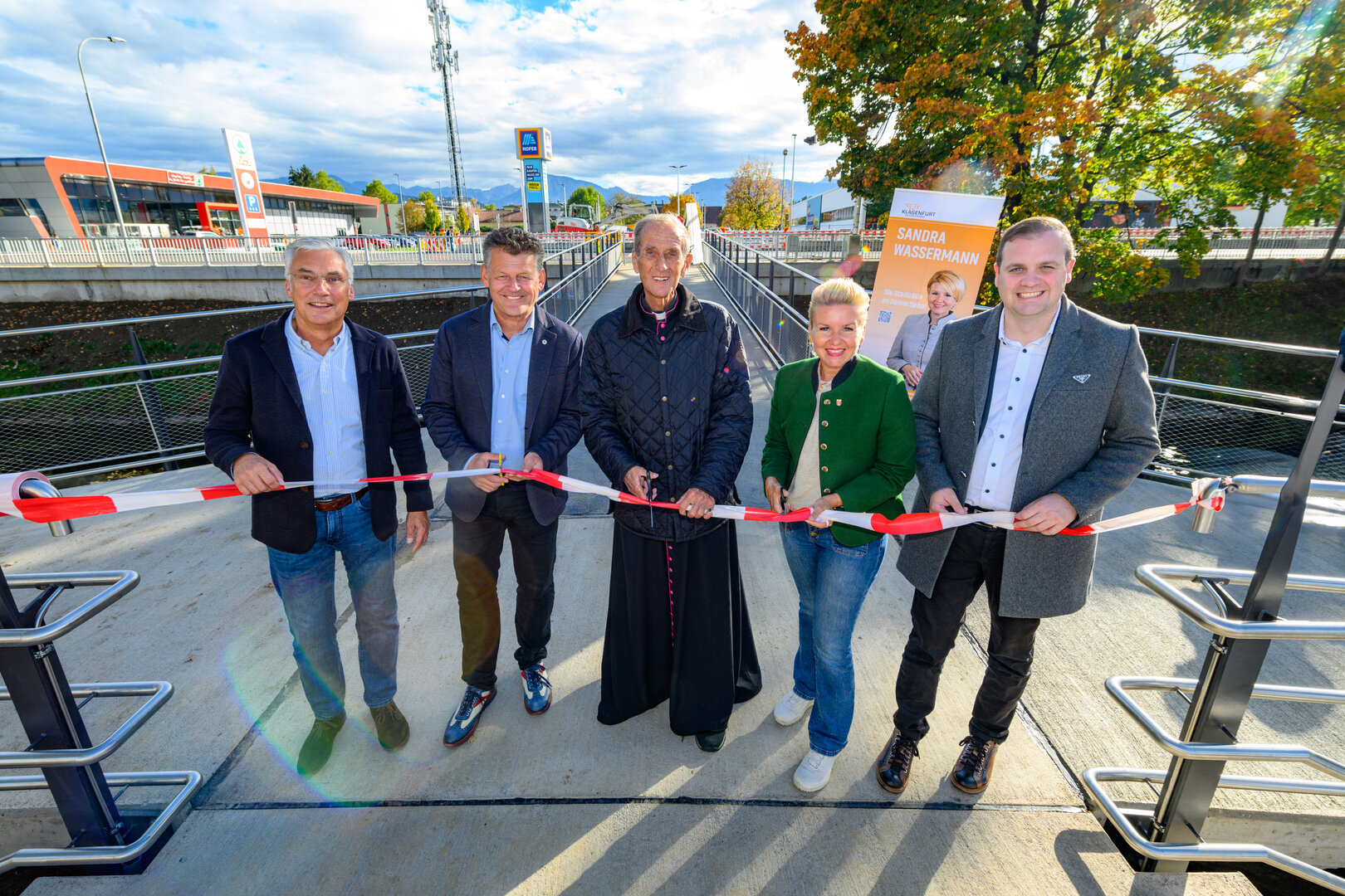 Architekt DI Herbert Horn, Bürgermeister Christian Scheider, Pfarrer Emmanuel Longin, Straßenbau- und Verkehrsstadträtin Sandra Wassermann, BA MA und Vizebürgermeister Patrick Jonke (v.l.n.r.) durchschnitten das symbolische Band zur Eröffnung.