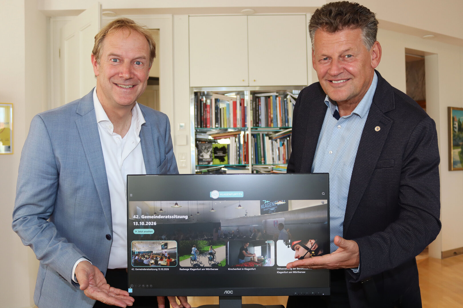 Bürgermeister Christian Scheider und Dr. Valentin Unterkircher, Leiter der Abteilung StadtKommunikation, präsentieren das neue moderne Design von Klagenfurt TV. Foto: StadtKommunikation/Buchner